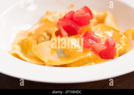 Köstliche gefüllte Mezzaluna Pasta von Grund auf mit Erbstück Tomate gemacht Soße Stockfoto