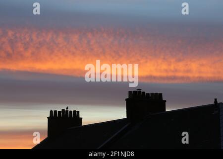 Ayr, Ayrshire, Schottland, Großbritannien. 25. Juni 2018. Schornsteintöpfe, die gegen einen Sonnenuntergang silhouetted, genommen von einem Nachbarhaus Stockfoto