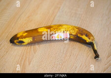 POZNAN, POLEN - 01. Apr 2016: Überreife Banane mit Markenaufkleber auf Holzhintergrund Stockfoto