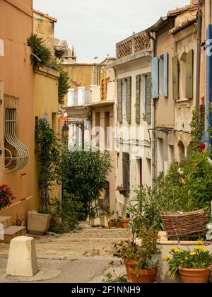 Pflastersteintreppe in der engen Straße, mittelalterliche Häuser mit Topfblumen im historischen Zentrum von Arles in der Provence im Sommer dekoriert. Stockfoto