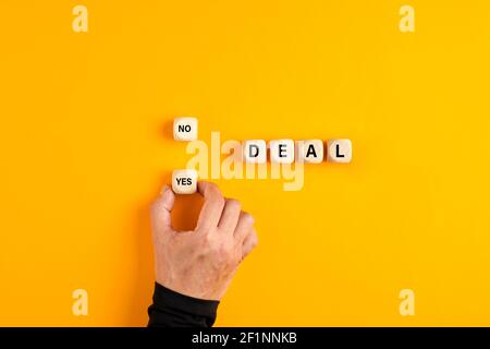 Das Wort Deal auf Holzblöcke mit einer männlichen Hand die Wahl ja Option. Um ein Geschäftsabschlusses zu akzeptieren. Stockfoto