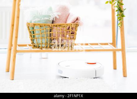 Roboter-Staubsauger unter Holzregal Stockfoto