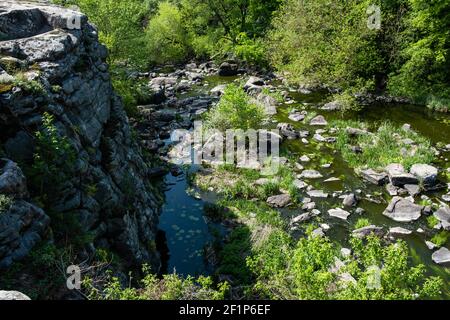 Ruhiger Fluss fließt in Canyon mit überhängenden Klippen an zwei Ufern, Buky Canyon, in der Nähe von Dorf Buki, Tscherkassy Region, Ukraine Stockfoto