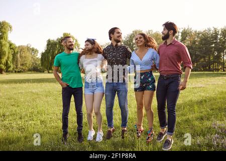 Millennial Freunde genießen ihre Zeit im Freien. Fröhliche Mädchen und Jungs verbringen Sommertag auf dem Land Stockfoto