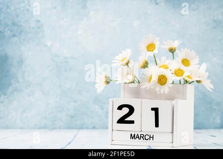 White Cube Kalender für märz mit Gänseblümchen über geschmückt Blauer Hintergrund mit Kopierbereich Stockfoto