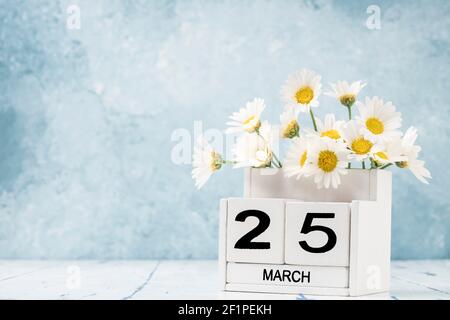 White Cube Kalender für märz mit Gänseblümchen über geschmückt Blauer Hintergrund mit Kopierbereich Stockfoto