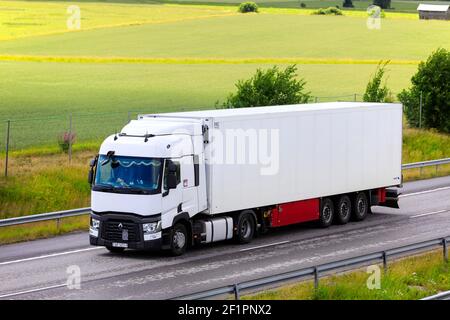 White Renault Trucks T von zieht gekühlten Sattelauflieger auf Highway 1 durch die finnische Landschaft. Salo, Finnland. Juli 10, 2020. Stockfoto