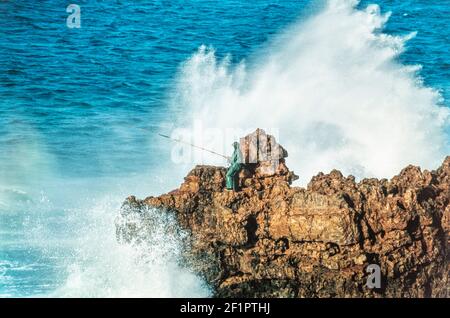 1998 - Algarve Carrapateira - Portugiesische Fischer Fischen von den Felsen bei extremen Wetterbedingungen mit viel Spray von den hohen Gezeiten an den Felsen, Carrapateira in der extremen Surf-Spray Carrapateira, Algarve, Portugal, EU, Europa Stockfoto