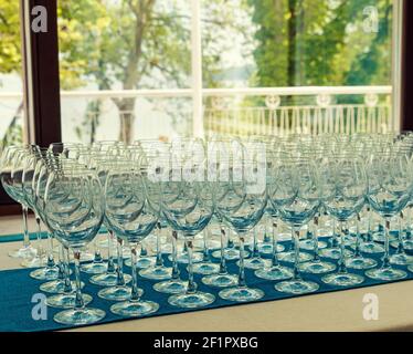 Viele leere Weingläser in einer Reihe auf einem Tisch In einem Restaurant Stockfoto