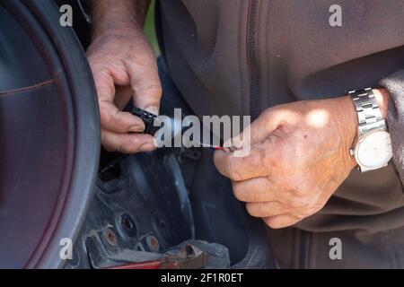 Mechaniker, der eine Autobeleuchtung in einer Garage repariert Stockfoto