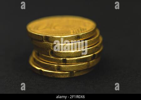 Ein Stapel goldener Euro-Münzen auf schwarzem Hintergrund, Makrofoto Stockfoto