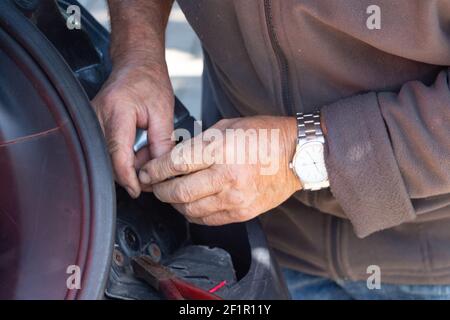 Mechaniker, der eine Autobeleuchtung in einer Garage repariert Stockfoto