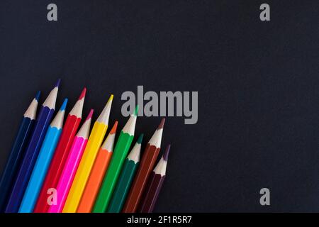 Buntstifte auf schwarzem Hintergrund mit Platz für Text. Stockfoto