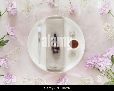 Flach legen, kosmetische Zusammensetzung mit natürlichem Öl, Beauty-Accessoires, Massagesteine und Chrysanthemen Blumen. Hautpflege Lifestyle-Konzept. Vorbereitung Stockfoto