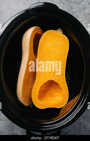 Zwei Hälften Butternusskürbis in einem Crockpot Stockfoto