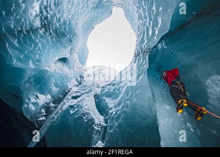 Mann klettert Eiszapfen in der Gletscherhöhle in Island Stockfoto