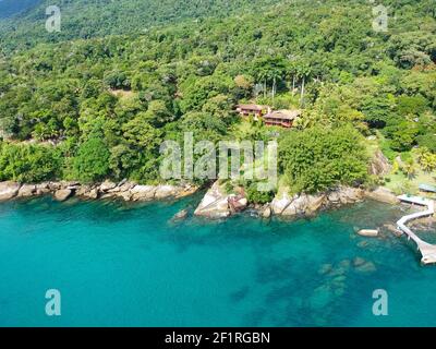 Luxuriöses Haus im tropischen Wald umgeben von Bäumen und neben Zum Meer und blau türkisfarbenem Wasser Stockfoto