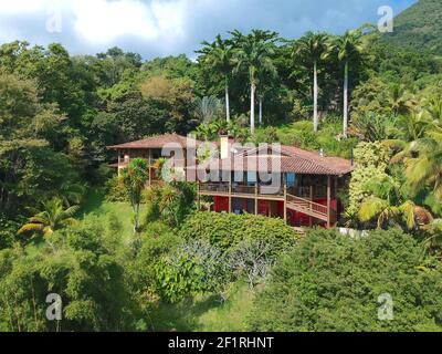 Luftaufnahme von Luxus-Holzhaus im tropischen Wald von Bäumen umgeben. Stockfoto