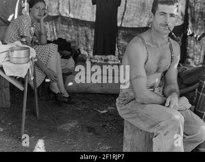 Arbeitsloser Holzarbeiter auf dem Weg mit seiner Frau zur Bohnenernte. Notieren Sie sich seine Sozialversicherungsnummer tätowiert auf seinem Arm. Oregon. - Foto von Dorothea lange Stockfoto