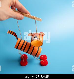 DIY Toilettenpapierrolle Handwerk, hausgemachte Tiger Spielzeug für Kinder, Marionette aus recycelten Materialien Stockfoto