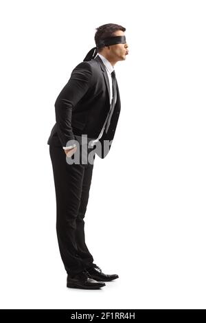 In voller Länge Profilaufnahme eines jungen Mannes in einem Anzug mit Augenbinde weht ein Kuss isoliert auf weißem Hintergrund Stockfoto