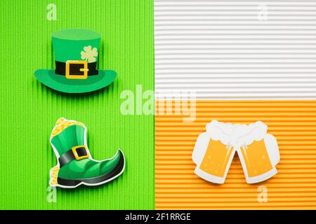 St. Patricks Day Hut und Bier auf grünem und orangefarbenem Hintergrund mit Kopierraum. Stockfoto