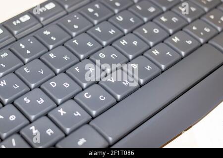 Tasten auf einer grauen Tastatur schließen sich auf einem Holztisch an Stockfoto