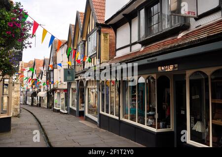 Billige Straße, eine enge mittelalterliche Fußgängerzone in Frome, Somerset mit einem kleinen Bach, der an einem frühen, ruhigen Sommertag in der Mitte des Zentrums fließt. Stockfoto