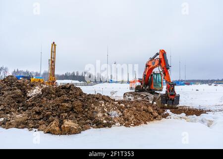 Baumaschinen: Bagger, Bohrgerät, Baustelle im Winter. Technische Umfragen und Kommunikation. Bau der Gasversorgung Stockfoto