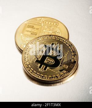 Zwei gold Bitcoins auf einem hellgrauen Hintergrund in einem Konzept der virtuellen Finanzen, cryptocurrencies und Investitionen Stockfoto