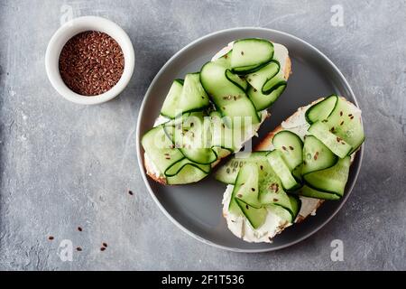Sandwiches mit Frischkäse und Gurke auf einem grauen Tisch. Stockfoto
