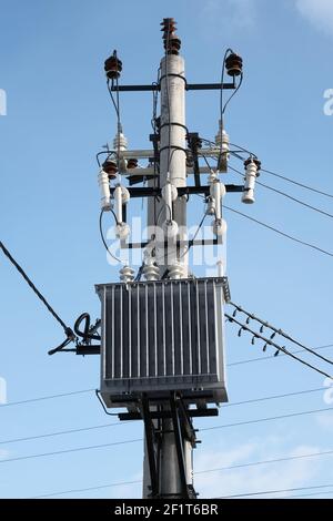 Transformator auf einem Mast auf blauem Himmel Hintergrund montiert Stockfoto