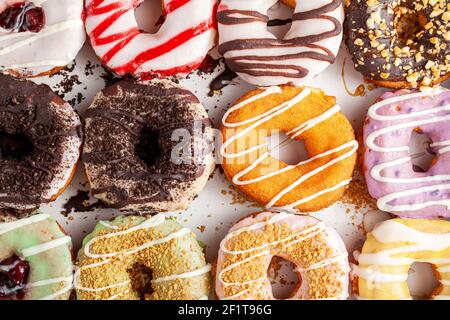 Flach Lay Draufsicht Bild von einem Dutzend Donuts auf Karton-Box. Ein köstliches Sortiment mit verschiedenen Geschmacksrichtungen und Belägen. Eine lebendige bunte Vielfalt pa Stockfoto