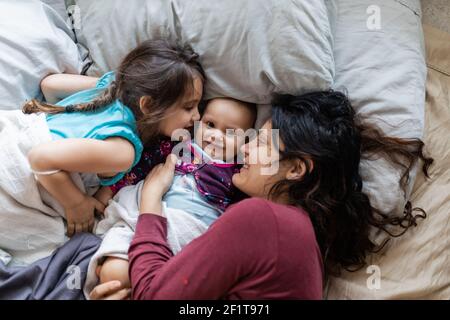 Mutter und ihre beiden Töchter liegen im Bett Stockfoto
