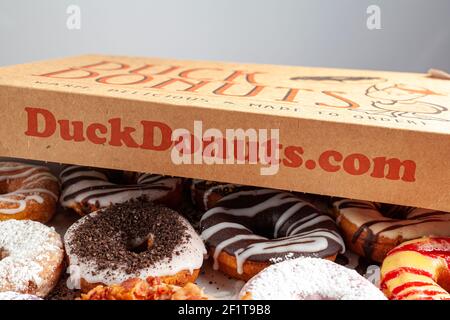 Clarksburg, MD, USA 03-04-2021: Ein Karton mit einem Dutzend Donuts, die im Laden Duck Donuts gekauft wurden. Eine beliebte Auswahl an verschiedenen Donuts sind Stockfoto