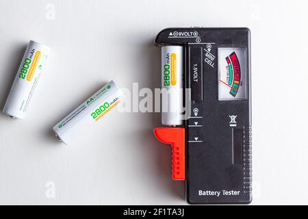 Ein schwarzer Batterietester aus Kunststoff mit einer Klemme an der Seite, mit der verschiedene Batterietypen eingesetzt werden können, damit deren Ladezustand gemessen werden kann. Stockfoto