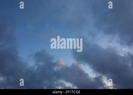 Verträumt, feenschwanz wie, blau und lila Wolken auf einem Sonnenuntergang Himmel mit hellen Mond Stockfoto