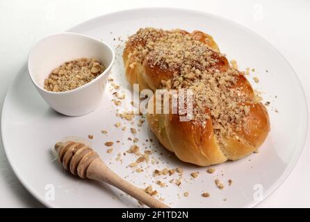 Rumänische Küche. Hausgemachte Mucenici, traditionelle Desserts in der Figur 8 gemacht, mit Honig und gehackten Nüssen isoliert auf weißem Hintergrund verschmiert. Stockfoto