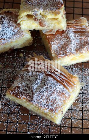 Griechische Küche. Bougatsa, hausgemachtes traditionelles Dessert mit Phyllo-Gebäck gefüllt und Sahne. Selektiver Fokus. Stockfoto