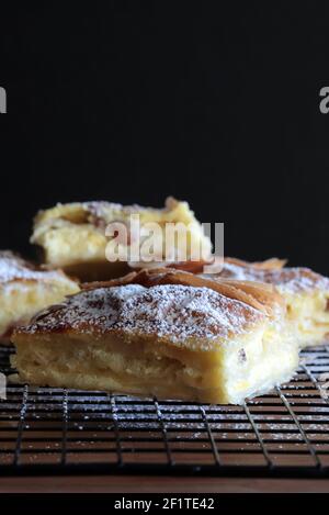 Griechische Küche. Bougatsa, hausgemachtes traditionelles Dessert mit Phyllo-Gebäck gefüllt und Sahne. Selektiver Fokus. Stockfoto