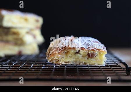 Griechische Küche. Bougatsa, hausgemachtes traditionelles Dessert mit Phyllo-Gebäck gefüllt und Sahne. Selektiver Fokus. Stockfoto