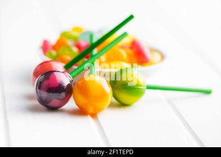 Süße, fruchtige Lutscher und Jelly Beans auf weißem Tisch. Stockfoto
