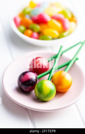Süße, fruchtige Lutscher und Jelly Beans auf weißem Tisch. Stockfoto