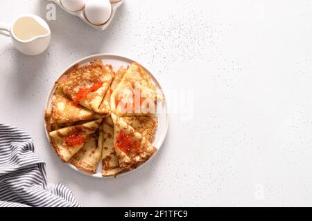 Russische Blini mit rotem Kaviar auf weiß. Draufsicht. Fasching. Stockfoto