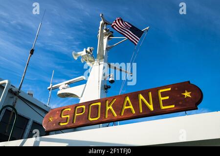 Washington State Ferry Spokane Holzschild unter blauem Himmel und Eine amerikanische Flagge Stockfoto