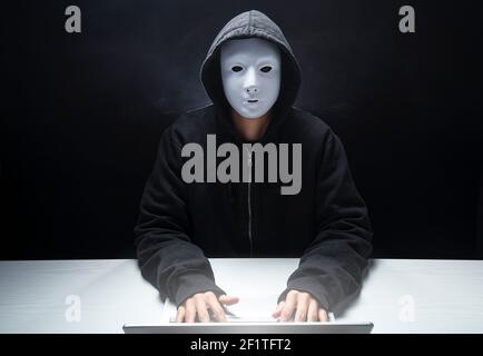 Anonymer Hacker mit Haube und Maske Verletzung sensibler Daten durch Verbreitung von Viren Stockfoto