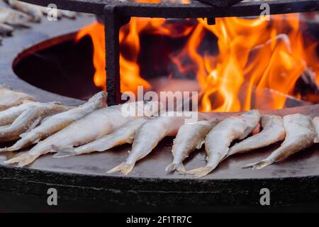 Prozess des Kochens europäischen gerochen Fisch auf Brazier mit heißer Flamme: Street Food Stockfoto