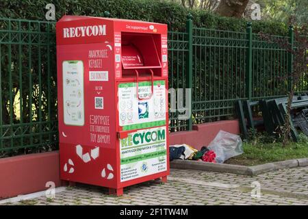 Peristeri Attiki, Griechenland-Dezember 19, 2020 - Rote Kleidung und Schuhe Papierkorb, Drop-off-Point.Spende Station für Schuhe, Textil, Kleidung collecti Stockfoto