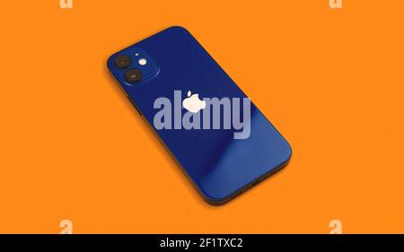 Charkow, Ukraine - 8. März 2021: Apple iPhone 12 mini blau auf orangem Hintergrund, Rückansicht mit Logo, isoliert Stockfoto