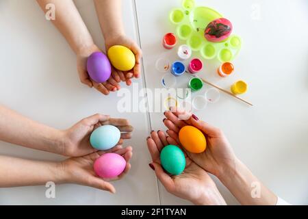 Die Hände der Familienmitglieder halten viele bemalte Ostereier. Osterdekoration Konzept Stockfoto